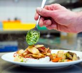 In the kitchen, the chef prepares the dish