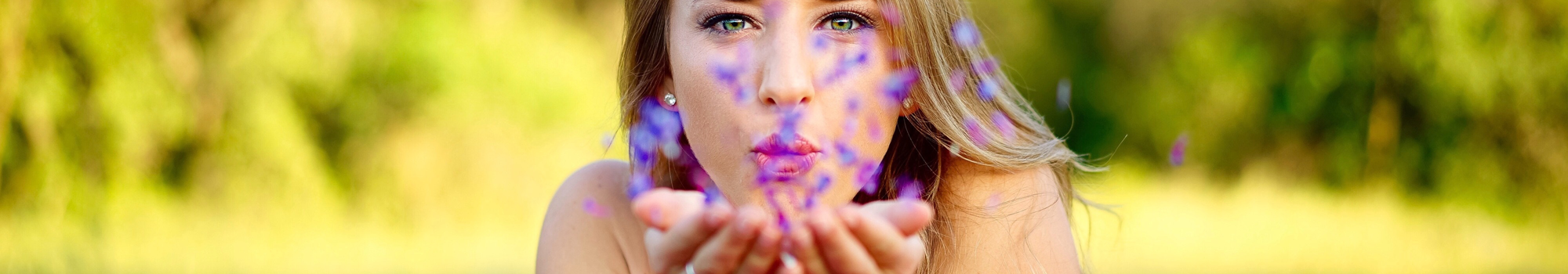 Femme qui souffle dans des fleurs