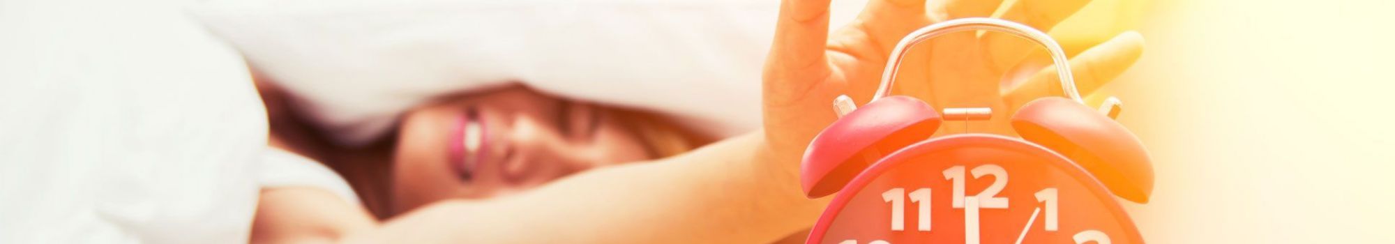 Femme souriante qui pose sa main sur son réveil